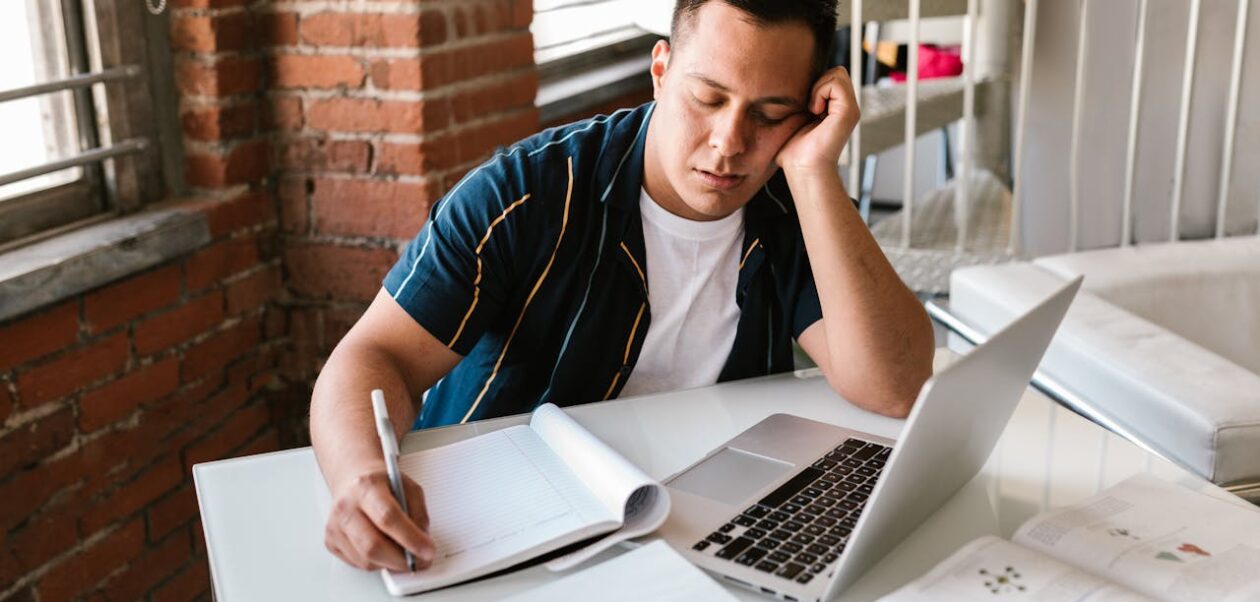 The 2-Minute Rule illustration showing a tired man struggling to start work at his laptop.