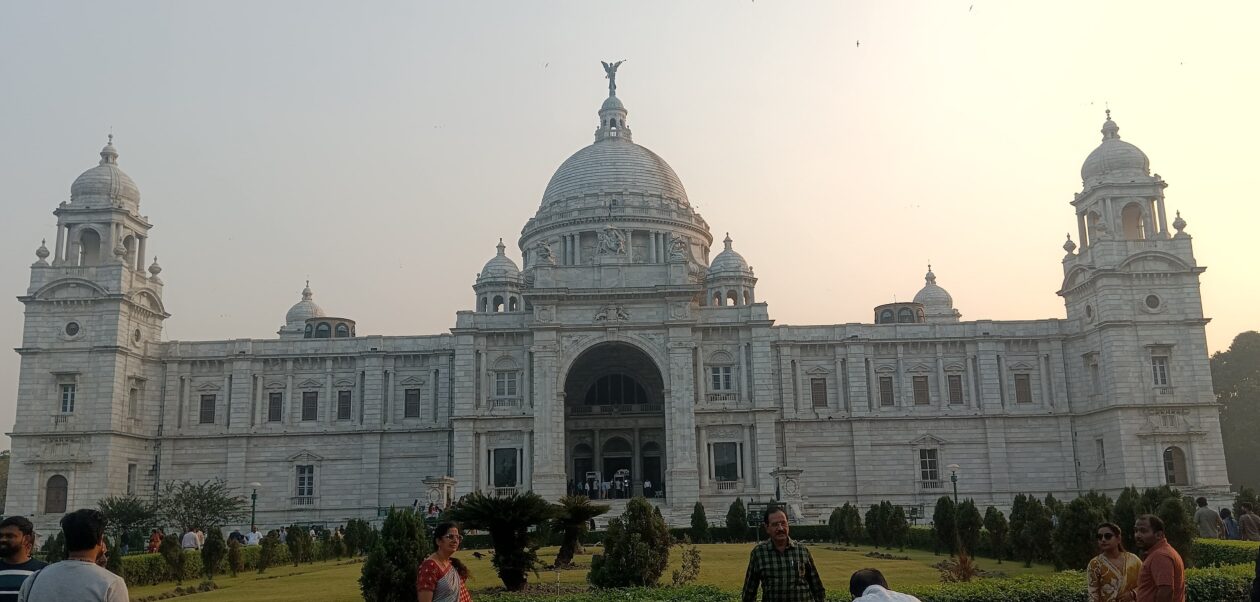 Victoria Memorial in Kolkata, a major West Bengal tourist destination, with visitors exploring the gardens during sunset.